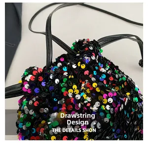 Gros plan des paillettes multicolores et du cordon de serrage noir sur le sac
