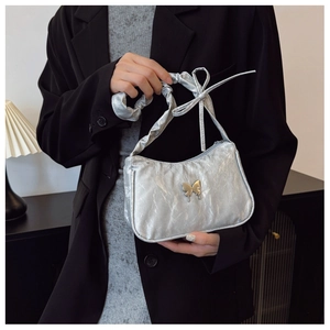 Détail du sac à main argenté métallisé avec texture froissée et fermoir papillon