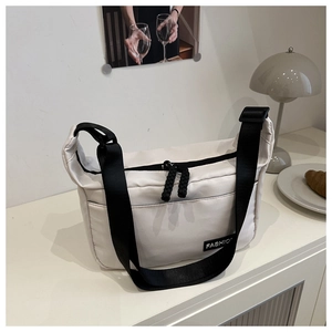 Detail of off-white nylon crossbody bag with black strap and Fashion woven label