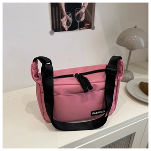 Detail of pink nylon tote bag with black adjustable strap and FASHION woven label