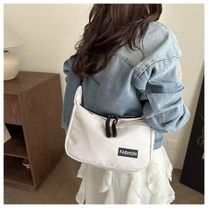 Detail of white nylon crossbody bag with double zippers and black woven pullers