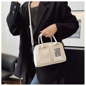 Chic cream-colored Boston shell bag styled on a black blazer for a modern fashion look