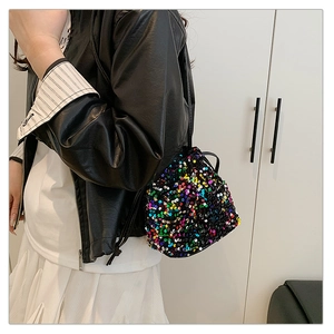 Détail d'un sac seau à paillettes colorées avec cordon de serrage et bandoulière noire