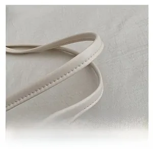 Detail of the high-quality cream tote bag's handle with precise stitching and soft texture