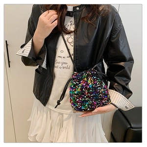 Vue détaillée d'un sac seau à paillettes colorées porté par un mannequin