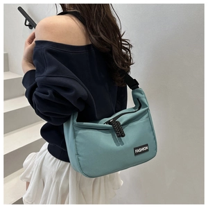 Detail view of light blue nylon crescent bag with adjustable strap on a model
