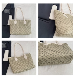 Detail view of large tote bag featuring grey M letter print and beige leather handles