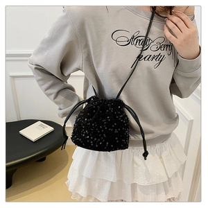 Detail of a chic black sequin bucket bag with drawstring closure and slim shoulder strap