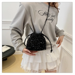 Gros plan sur les paillettes noires scintillantes et le cordon du sac seau tendance