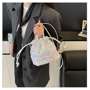 Macro detail of iridescent sequins and drawstring closure on white bucket bag