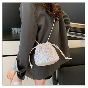 Detail of sequin bucket bag featuring iridescent finish and drawstring closure