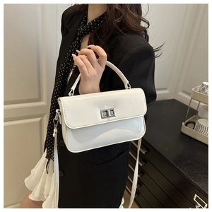 Détail d'un sac à main blanc en cuir avec fermoir argenté porté par un mannequin