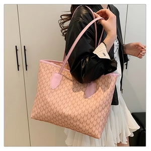 Detail showing the pink faux leather tote bag with M-letter monogram and long shoulder straps