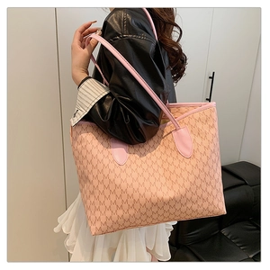 Detailed shoulder view of pink monogram tote bag with letter M pattern and slim straps