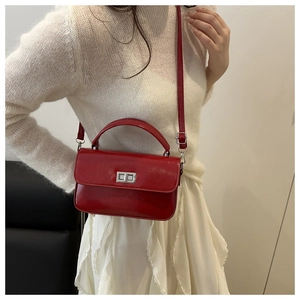 Gros plan du sac à main en cuir verni rouge avec fermoir rotatif argenté élégant
