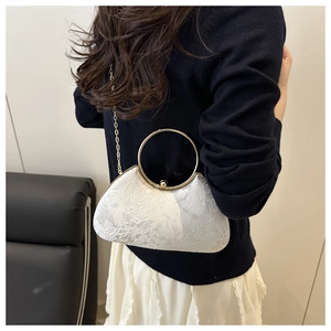 Detail of white embroidered half-moon evening bag with golden handle and chain strap