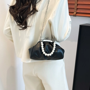 Elegant black cloud evening bag with pearl handle and metal chain shown in lifestyle setting