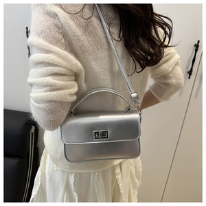 Sac à main en cuir PU argenté avec fermoir rotatif porté par un mannequin