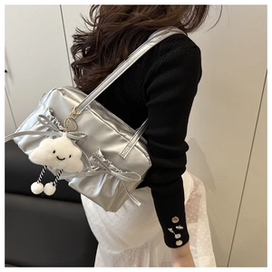 Sac oreiller argenté métallisé avec nœuds et breloque peluche porté par un mannequin