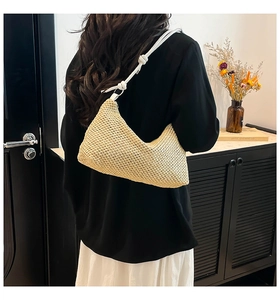 Detail of hand-woven straw tote with elegant white knotted shoulder strap detail