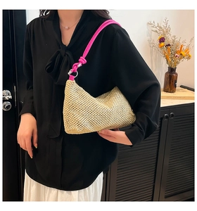 Detail of beige straw bag with bright pink knotted rope strap and metal ring