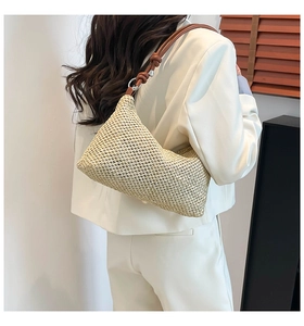 Detail view of woven paper rope bag featuring brown knotted strap and silver metal ring