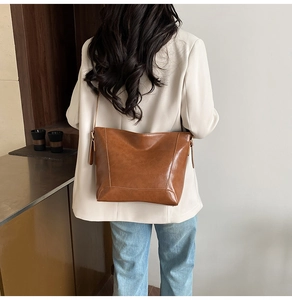 Lifestyle view of brown vegan leather tote bag worn by model in minimalist studio