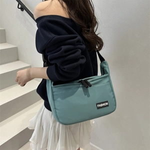Large mint green nylon tote bag with fashion label shown on model with shoulder strap