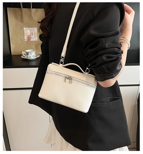 Close-up of cream white lychee texture leather vanity bag with silver zippers and handle