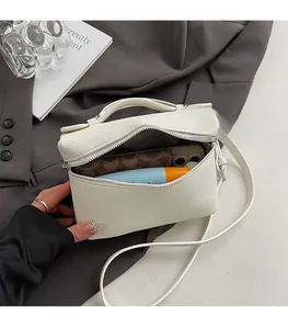 Detailed view of white litchi grain leather crossbody bag showing interior storage capacity