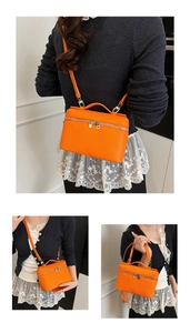 Three-way view of bright orange litchi grain box bag with top handle and crossbody strap