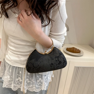 Elegant black velvet handbag with floral patterns and gold metal ring handle