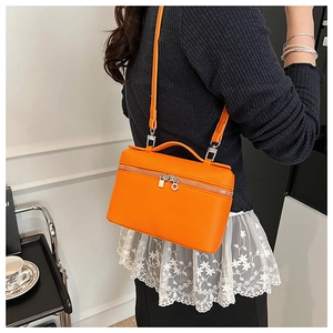 Detail of orange lychee texture box crossbody bag with metal zipper and leather handle