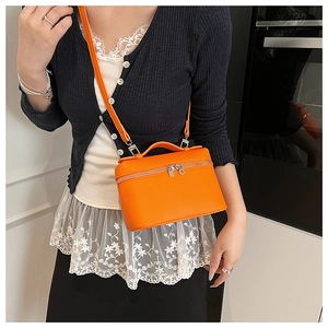 Orange lychee pattern vanity case bag shown as a crossbody for daily commuting