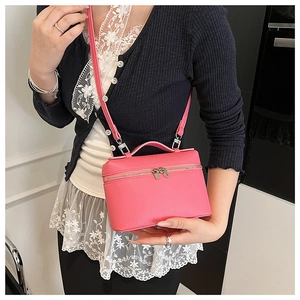 Detail of rose pink pebbled leather crossbody bag with silver double zipper and handle