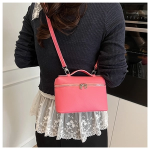 Rose pink litchi grain leather crossbody vanity bag shown on model for size reference