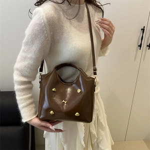Deep brown glossy patent leather tote bag with unique golden dog metal ornament