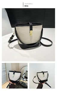 Detail view of woven bucket bag featuring black leather trim and golden twist lock closure