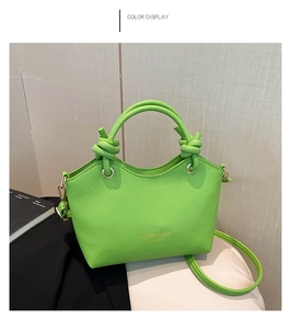 Detail of neon green lychee pattern leather tote with knot handle and gold lettering