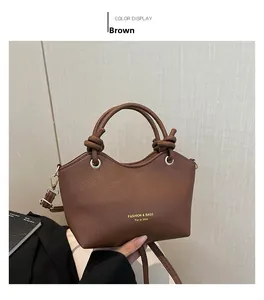 Close-up of brown bucket bag with braided handle and gold Fashion & Bags lettering