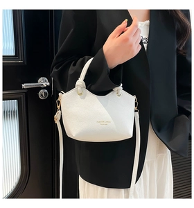 Close-up of white lychee-patterned tote bag with golden hardware and adjustable strap