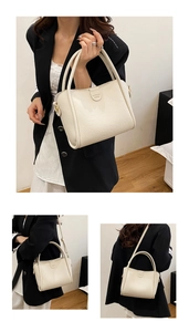 Detail view of beige lychee pattern bucket bag showing hand-carry and crossbody styling