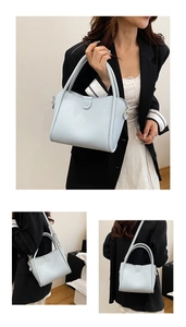 Detail view of light blue tote bag with lychee grain leather and adjustable strap