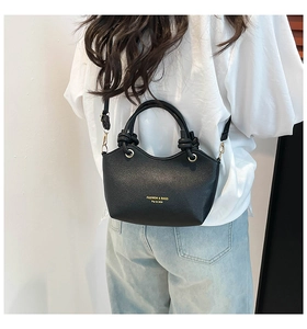 Detail showing back view of black lychee leather bucket bag worn by model