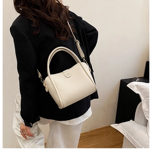 Rear view of cream lychee texture tote bag worn as a crossbody for daily commute style