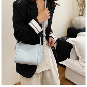 Detail of light blue lychee pattern leather bucket bag with adjustable shoulder strap