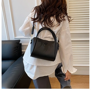 Detail of a black lychee texture leather handbag shown on a model for daily commuting