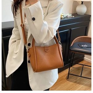 Detail of brown lychee grain leather tote bag with top handle and adjustable strap