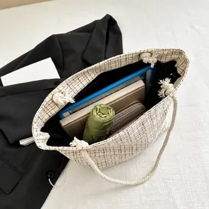 Interior storage view of large tweed tote bag holding a tablet, umbrella and wallet