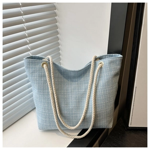 Détail du sac cabas en tweed bleu clair avec texture tissée et poignées en corde